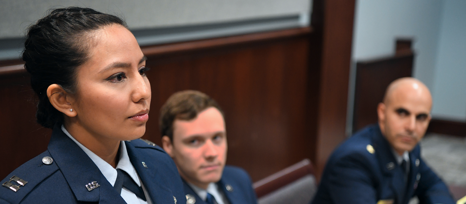 a female JAG attorney standing up, while another one sitting down is looking at her